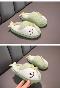 Primo piano di graziose pantofole in peluche verdi a forma di pesce per bambini