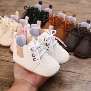 Primer plano de zapatos blancos para bebé con cordones y textura de piel sintética suave