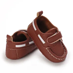Detailansicht brauner Baby-Loafer mit Klettverschluss, weicher Sohle und weißen Nähten.