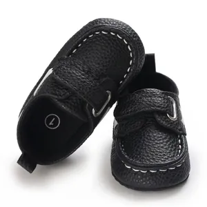 Nahaufnahme von schwarzen Baby-Mokassins mit weißen Ziernähten