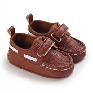 Nahaufnahme von braunen Baby-Lederschuhen mit weicher Sohle und weißen Nähten.