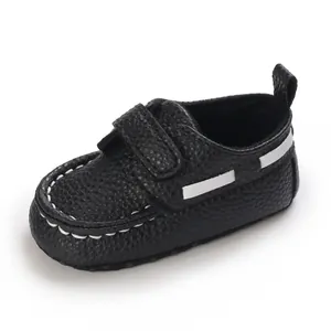 Detailansicht schwarzer strukturierter Babyschuhe aus Leder mit weißen Ziernähten