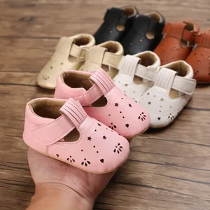 Nahaufnahme von rosa Baby-Lauflernschuhen aus Leder mit sternförmigen Ausschnitten