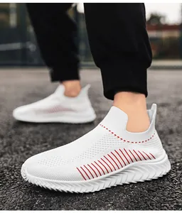 Primo piano di scarpe sportive da uomo in fly-knit bianche e traspiranti con strisce rosse