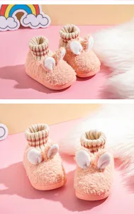 Detail von süßen rosa flauschigen Kinderhausschuhen mit weißen Hasenohren und Strickbündchen