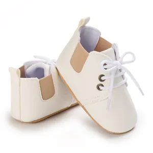 Primer plano de zapatos de bebé color crema con suelas blandas y cordones blancos