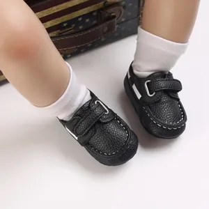Detailaufnahme von schwarzen Baby-Lederpatscherln mit Klettverschluss und weißen Nähten