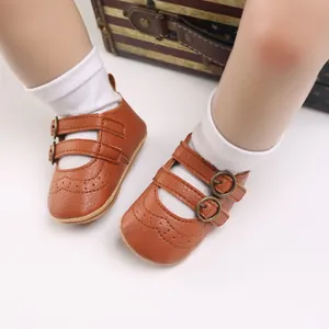Detail of brown faux leather baby princess shoes with soft soles on white socks