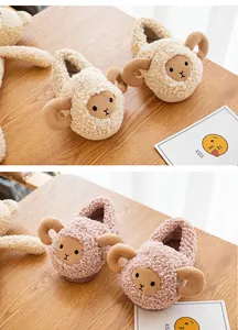 Detail showing cute plush sheep cartoon slippers for toddlers in pink and cream colors.