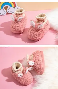 Detail der rosafarbenen flauschigen Kinderhausschuhe mit Hasenohren und Strickbündchen