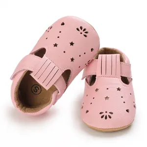 Nahaufnahme von rosa Baby-Lauflernschuhen mit Stern- und Blumenausschnitten