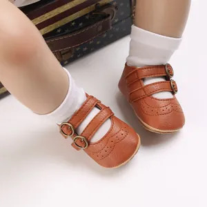 Macro detail of brown baby princess shoes featuring double buckle straps and soft soles