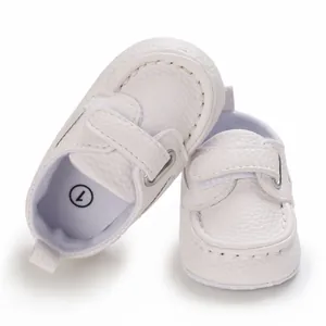 Nahaufnahme von weißen Baby-Slippern aus Leder mit Klettverschluss und weicher Sohle