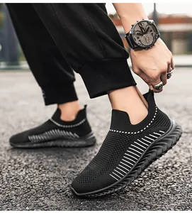 Dettaglio di scarpe sportive slip-on in maglia nera traspirante da uomo su asfalto