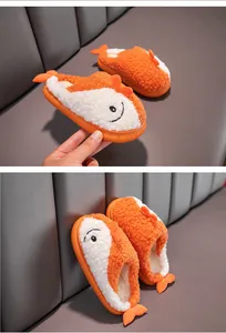 Dettaglio delle pantofole di peluche arancione e bianco a forma di pesce per bambini.