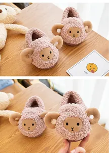 Close-up detail of cute pink cartoon sheep plush winter slippers for toddlers and kids.