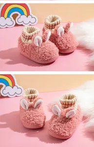 Detailansicht von rosa flauschigen Kinderhausschuhen mit Hasenohren und Strickbündchen