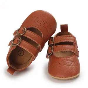 Close-up of brown leather baby princess shoes with double buckles and brogue details