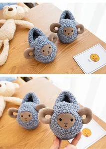 Detailed macro view showing the plush texture of blue cartoon sheep slippers for toddlers.