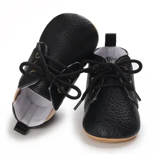 Vista detallada de zapatos negros de suela blanda para bebés con cordones clásicos