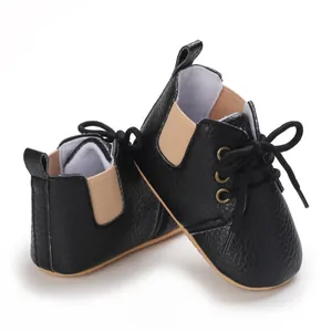 Detalle de vista lateral de zapatos negros de suela blanda para bebés de 0-1 año
