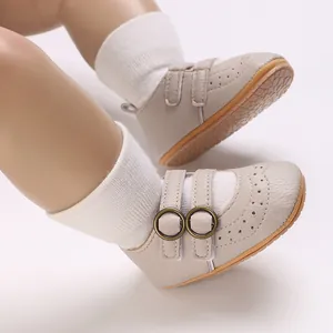 Close-up of beige soft-sole baby walking shoes with decorative brogue perforation details