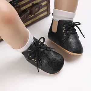 Vista detallada de zapatos de bebé negros con suela blanda para recién nacidos y niños