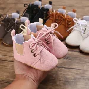 Primer plano de zapatos de bebé rosa con suela blanda y textura de cuero con cordones