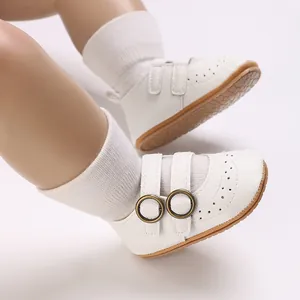 Close-up of white soft-sole baby pre-walker shoes with buckle and perforated detail