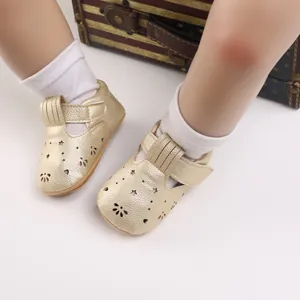 Detailansicht goldener Lauflernschuhe für Babys mit Sternenmuster und weicher Gummisohle.