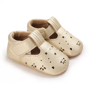 Nahaufnahme goldener Baby-Lauflernschuhe mit lasergeschnittenen Sternen- und Herzmustern