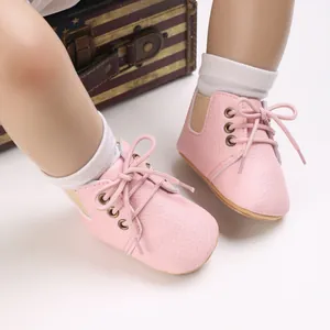 Detalle de los zapatos de bebé en color rosa con cordones y suelas muy blandas