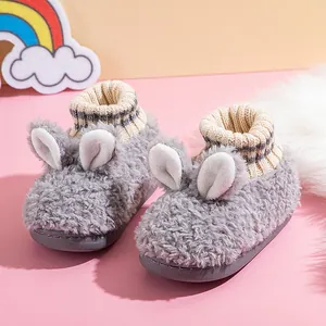 Süße graue Plüsch-Hasenhausschuhe mit Strickbündchen für Kinder im Innenbereich.