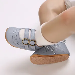 Close-up of blue soft-sole baby shoe featuring elegant brogue details and double strap buckles