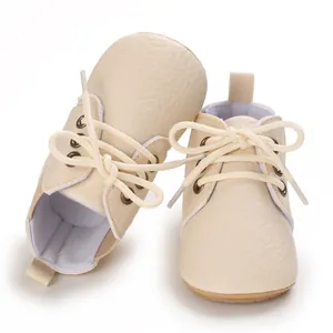 Detalle de los zapatos de caminar para bebés en cuero sintético crema con suela blanda