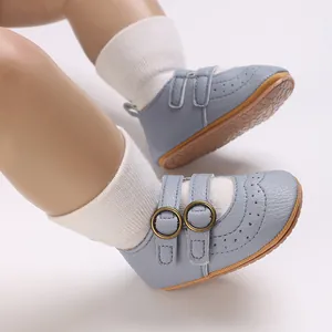 Close-up of soft-sole blue baby walking shoes with bronze buckles and brogue details