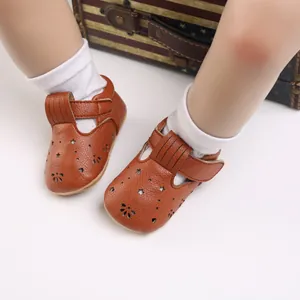 Nahaufnahme von braunen Baby-Lauflernschuhen aus Kunstleder mit Sternen und Fransen