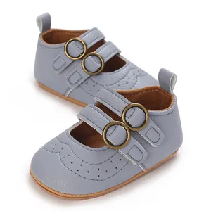 Detail view of baby blue soft-sole walking shoes with buckle straps and brogue patterns.