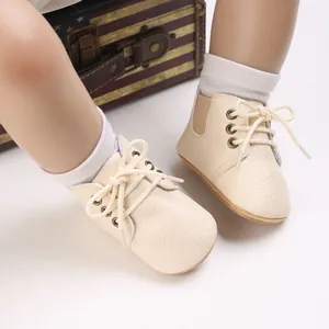 Primer plano de zapatos para los primeros pasos de bebé con suela blanda y cordones