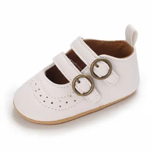 Close-up detail of white soft sole baby princess shoes with double bronze buckles
