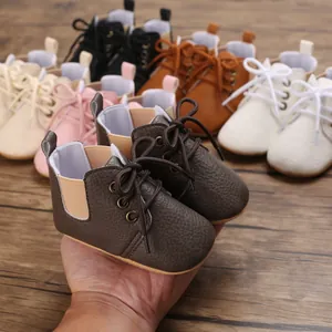 Vista detallada de zapatos para bebé con suela blanda en varios colores sobre madera.