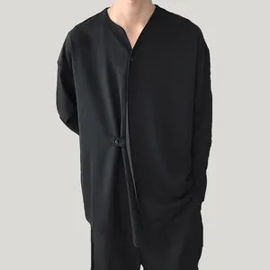 Detail van een zwart herenshirt met lange mouwen en onregelmatig gelaagd ontwerp