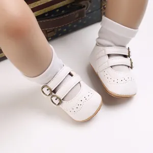 Detailed view of white baby princess shoes with brogue patterns and soft soles.