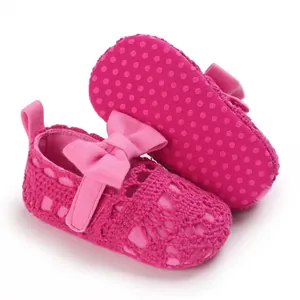 Detailansicht der rosa gestrickten Babyschuhe mit Schleife und rutschfester Sohle