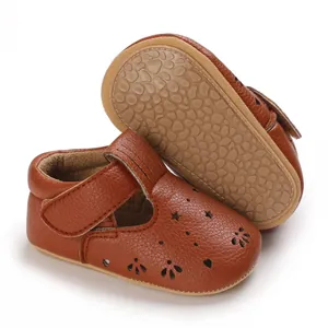 Nahaufnahme von braunen Baby-Prinzessinnenschuhen aus Leder mit strukturierter Anti-Rutsch-Sohle