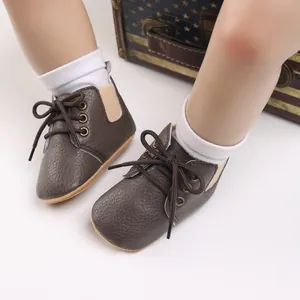 Primer plano detallado de zapatos de suela blanda para bebé en marrón con calcetines.