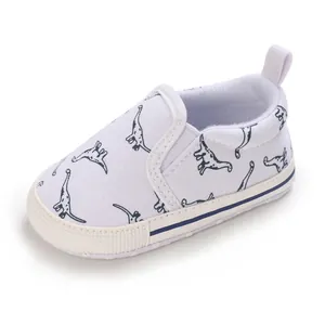 Detailed view of infant soft-soled walking shoes featuring navy dinosaur prints on white fabric