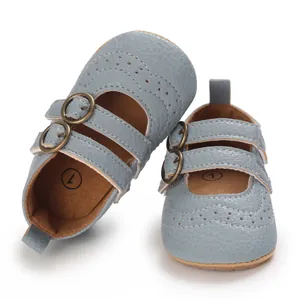 Close-up of blue soft-sole baby Mary Jane shoes with double bronze buckles.