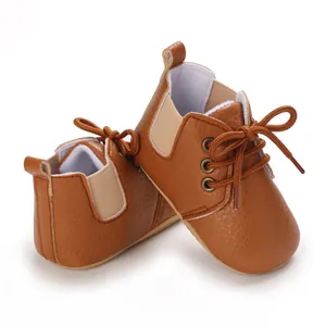 Vista detallada de zapatos de bebé marrón con suela blanda y diseño de cordones