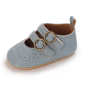 Detailed view of blue baby Mary Jane shoes with double bronze buckles and soft soles.
